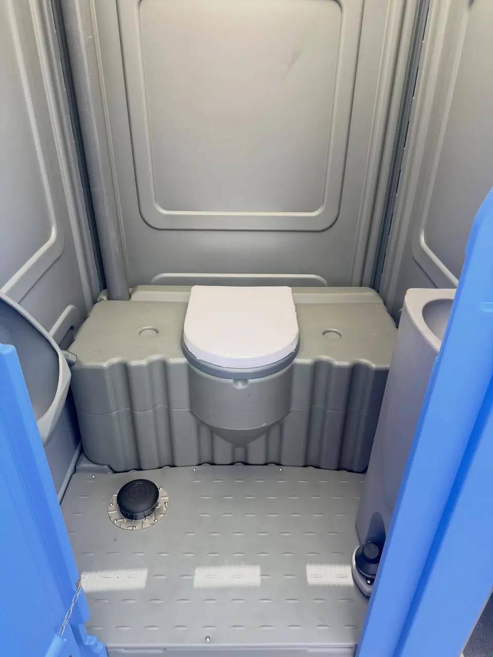 Clean porta potty interior with seat and vent