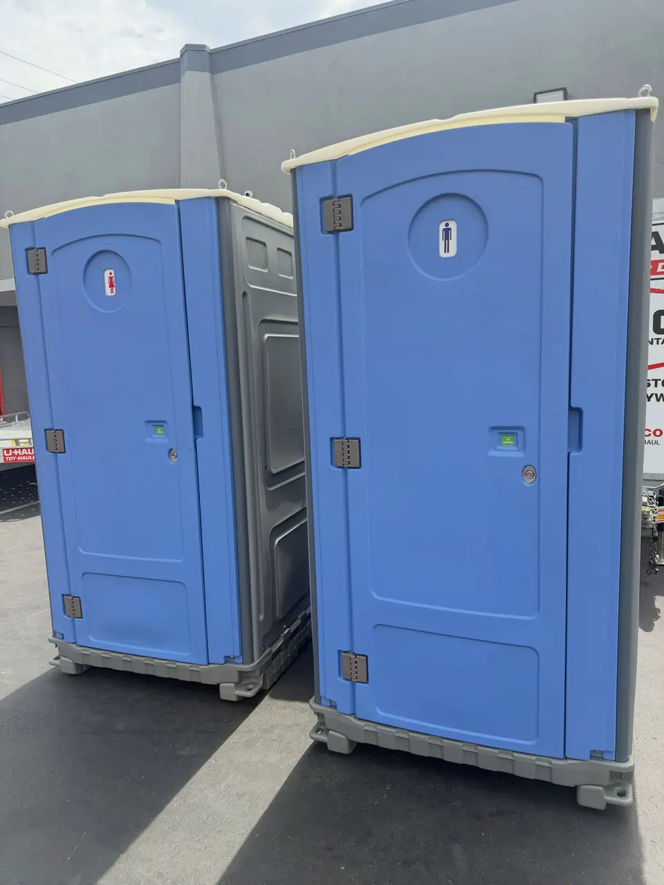 Two blue standard porta potties side by side
